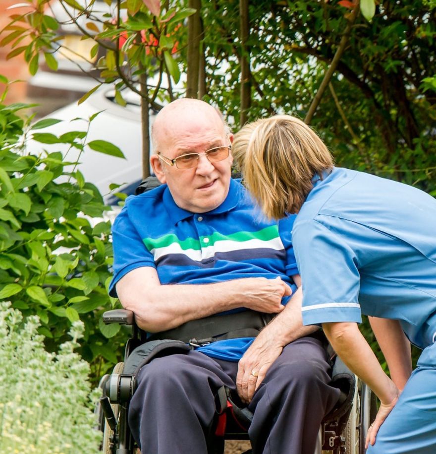 Elderly resident with member of staff in the garden