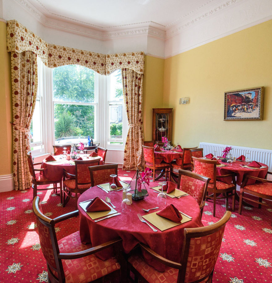Dining area with red carpets, tables and chairs